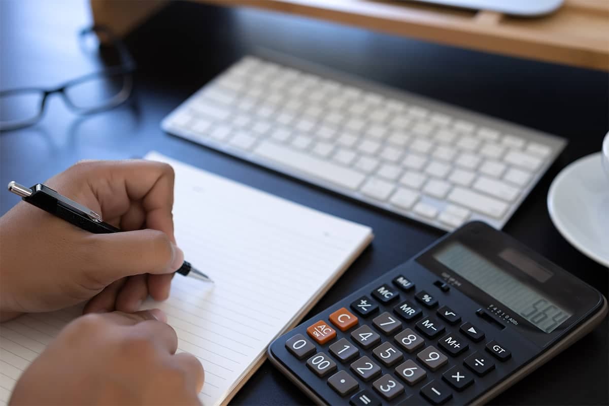 An engineer writing notes and using a calculator.